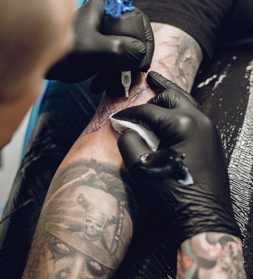 hombre-haciendo-tatuaje-salon-tatuaje_1157-24947